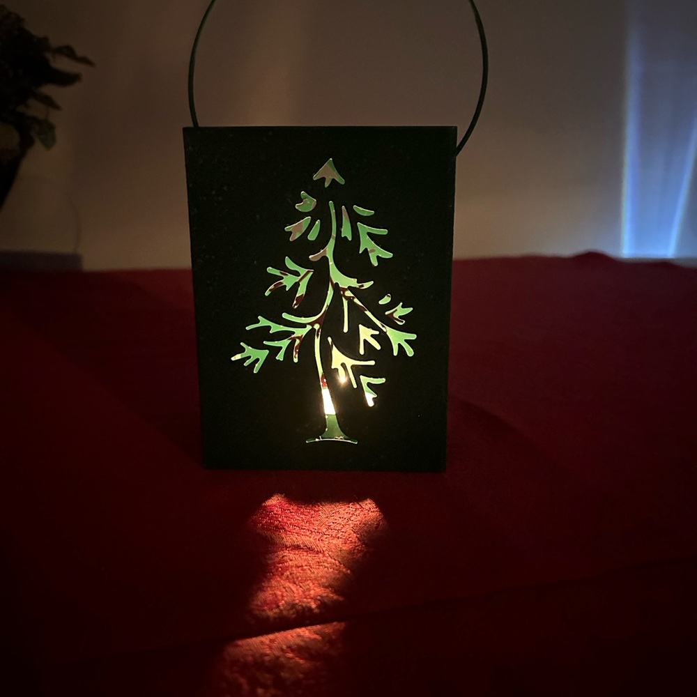 Ten green metal luminaries with Christmas tree cutouts